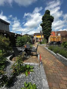 a patio with benches and a table and a tree at Oasen in Viborg