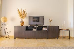 马尼尔瓦Coto Real Naxos 111的娱乐中心上方设有平面电视