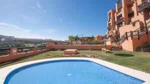 马尼尔瓦Coto Real Naxos 111的建筑物旁边院子里的游泳池