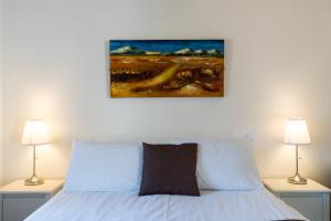 a bedroom with a white bed with two lamps at Owls Hoot at Tove Valley Cottages in Towcester