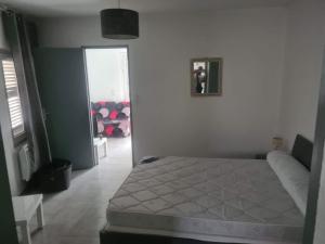 a bedroom with a bed and a door into a room at appartement indépendant CORTE in Corte