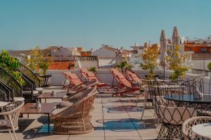 a patio with chairs and tables on a roof at Vincci Molviedro in Seville