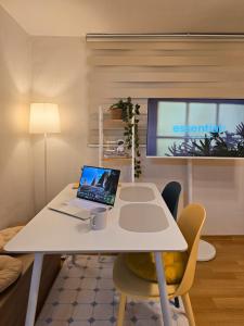 un ordinateur portable posé sur une table blanche dans une pièce dans l'établissement STAY EDGE GONGBAEK - near Shindaebang Station Boramae Hospital & Park Hongik University Airport Bus near Sindorim, Gangnam, à Séoul
