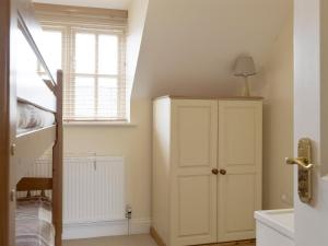 a room with a white cabinet and a window at Dormers in Leiston