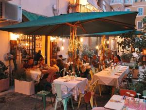 a group of people sitting at tables under an umbrella at La Casa Di Rita in Civitavecchia
