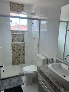 a white bathroom with a toilet and a sink at Estilo e Conforto Perto da Praia in Cabo Frio +10 photos