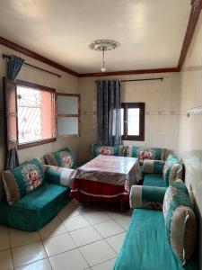 un soggiorno con tavolo e divani verdi di Klmmm ad Agadir