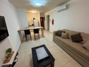 a living room with a couch and a table at Torre Orca Piso 9 Mareas del Golfo in Las Grutas