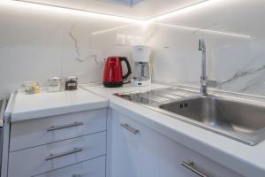 a kitchen with white cabinets and a sink at Helen's Little Castle free private parking in Thessaloniki