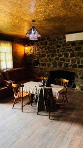 a living room with a table and a fireplace at Machakhela ODA in Tsʼkhemlisi