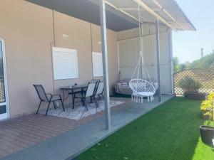 a porch with a swing and a table and chairs at MariAggela's Cosy House in Theologos