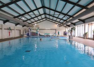 Una gran piscina cubierta con gente en ella. en Castle Brake Holiday Park, en Woodbury