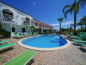 a swimming pool with lounge chairs and a hotel at Hotel MARINELLA parking wi-fi spiaggia attrezzata in Capo Vaticano