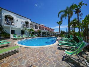 a resort with a swimming pool and lounge chairs at Hotel MARINELLA parking wi-fi spiaggia attrezzata in Capo Vaticano