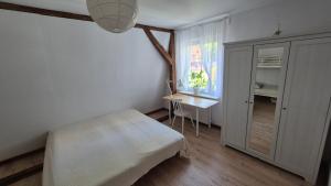 a bedroom with a bed and a table and a window at Apartament LUA in Ustka