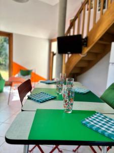 a table with green plates and glasses on it at Chez Raoul, maison agréable in Villebernier