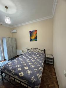 a bedroom with a bed with a comforter on it at zaza in K'obulet'i