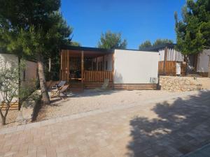 a house with a pavilion with chairs and a tree at Mobile home Tinkara Drage in Drage +6 photos