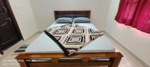 a bed with blue pillows on it in a room at thotadamane easystay in Chikmagalur