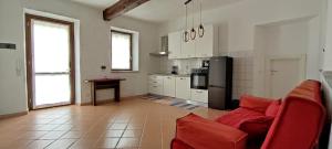 Una sala de estar con un sofá rojo y una cocina. en Casa Villa La Regina, en Venaria Reale
