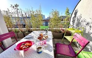 a table with a bowl of fruit on a balcony at Junior suite avec balcon in Lyon +22 photos