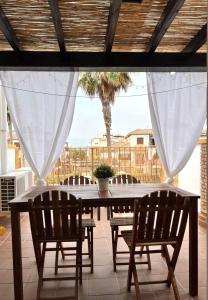 un tavolo e sedie su un patio con una palma di El Ático de Vera a Vera