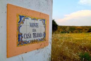 a sign on a wall next to a field at Monte da Casa Telhada in Santiago do Cacém +50 photos