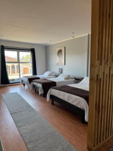 a room with three beds and a large window at Hotel y Restaurant Mackenna in Osorno