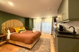 een slaapkamer met een bed met gele kussens en een keuken bij Refuge Urbain Quebec - Lofts de la Cité in Québec