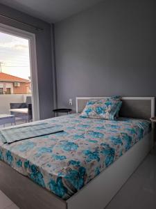 a bedroom with a bed with a blue comforter at MariGold Villa in Prinos
