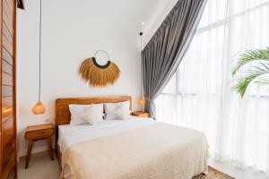 a bedroom with a bed and a large window at Sunrise Bliss 2 in Dalung