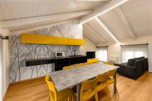 a dining room with a table and yellow chairs at La casa della Maestra Carolina in Ottiglio