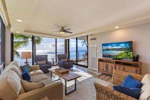 Una sala de estar con un sofá y un televisor. en Incredible Views Mahana 219, en Kahana