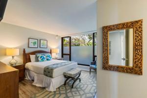 un dormitorio con una cama y un espejo en Incredible Views Mahana 219, en Kahana 72 fotos más