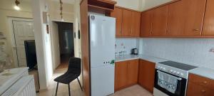 a kitchen with a white refrigerator and wooden cabinets at Harmony 3 in Artemida
