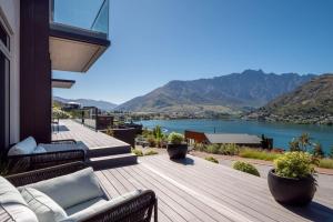 una casa con terrazza affacciata sull'acqua di The Middleton Room a Queenstown