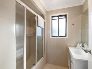 ein weißes Badezimmer mit Dusche und Waschbecken in der Unterkunft Sunnybank Hills Retreat 6 Beds Near Market Square in Brisbane