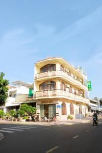 a building on the corner of a street with a motorcycle at Hotel Ngọc My in Phan Thiet
