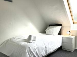a bedroom with a white bed with a window at Spacious Apartment for 5 in Odense