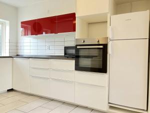 a kitchen with white cabinets and a refrigerator at Spacious Apartment for 5 in Odense