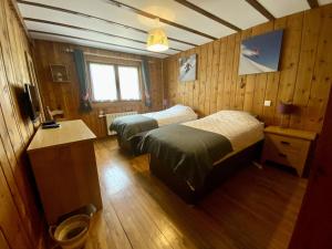 斯姿Chalet Des Sangliers的配有木墙和木地板的客房中的两张床