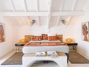 a bedroom with a bed and a table with shoes on it at Koala1 Elegant 1BR Duplex, Anse Marcel, Sea View in Anse Marcel 
