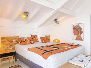 a bedroom with a large bed with orange pillows at Koala1 Elegant 1BR Duplex, Anse Marcel, Sea View in Anse Marcel  +5 photos