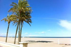 two palm trees and a bench on a beach at Planta Baja al al lado de Playa Arenas in Valencia +12 photos