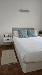 a bedroom with a large white bed with a night stand at Apartamento en la playa de Empuriabrava in Empuriabrava