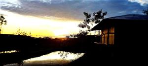 a silhouette of a building with the sunset in the background at Casa Vacacional - Yantza Tur in Palora