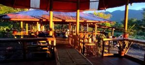 a restaurant with tables and chairs and a roof at Casa Vacacional - Yantza Tur in Palora