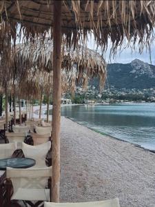 a row of chairs and tables on a beach at Galazio suites 2 Seaside in Salamina