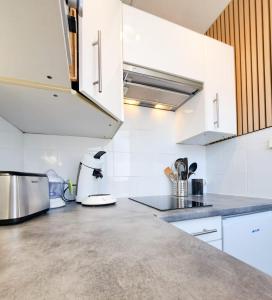 een keuken met witte kasten en een aanrechtblad bij Les Amoureux in Royan