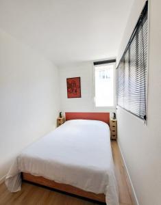 een witte slaapkamer met een bed en een raam bij Les Amoureux in Royan +10 foto's
